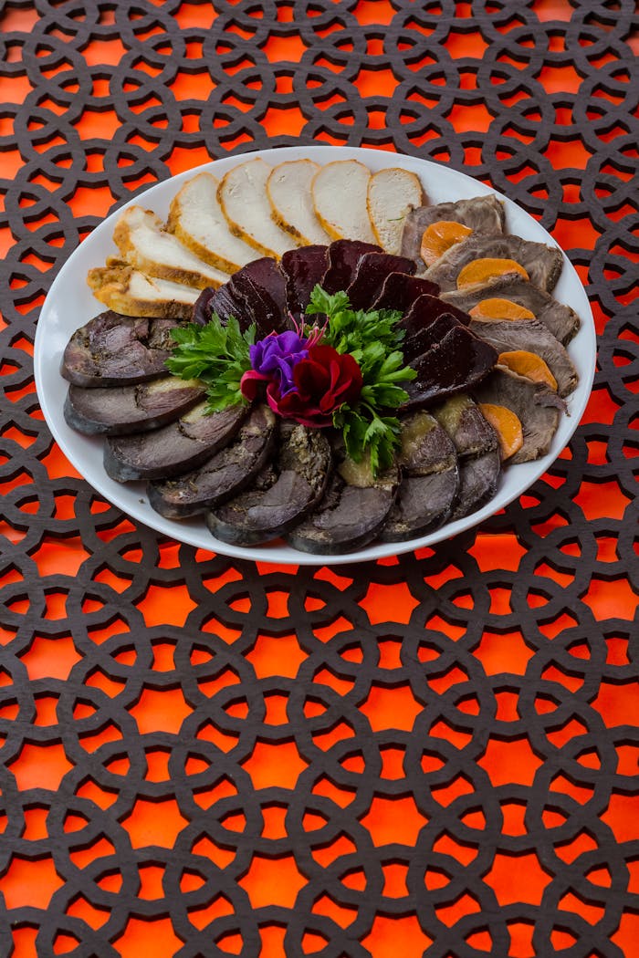 A stylish plate of assorted meats with a fresh floral garnish, perfect for culinary inspiration.